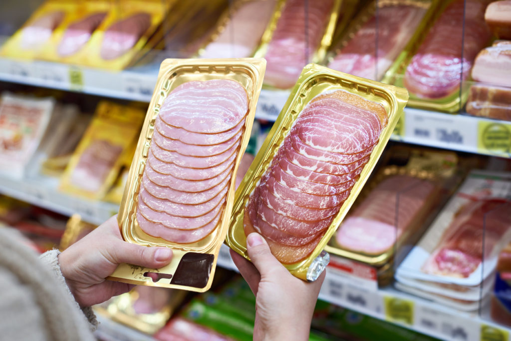 Woman chooses slice of ham at store